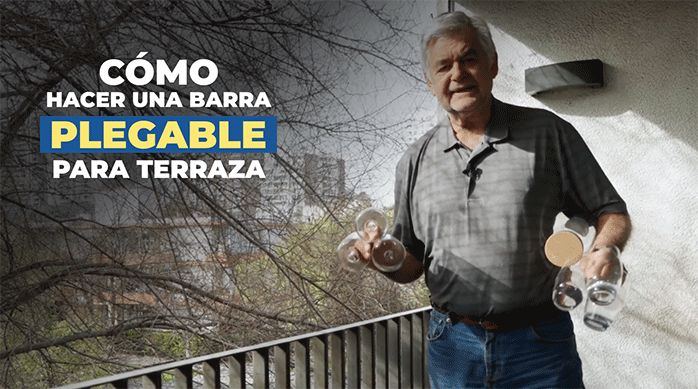 un hombre en un balcón sosteniendo barios vasos en las manos y listo para explicar cómo hacer una barra plegable para terraza.