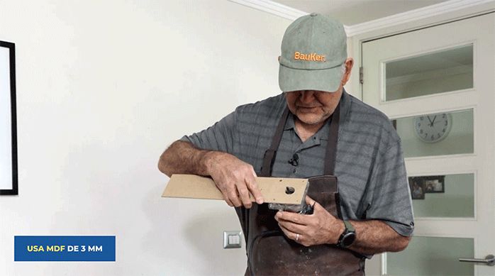 un hombre usa un trozo de mdf como plantilla para la fresadora.
