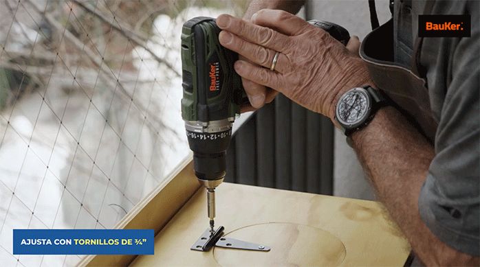 un hombre fija la tapa de la hielera usando tornillos.