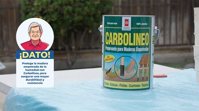 se muestra un tarro de preservante carbolineo sobre un mesón de trabajo.