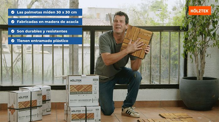 un hombre en un balcón muestra las palmetas para construir un deck de madera sobrepuesto.