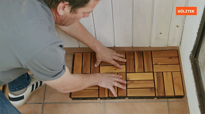 un hombre instala un deck de madera sobrepuesto en un balcón usando su sistema clic.