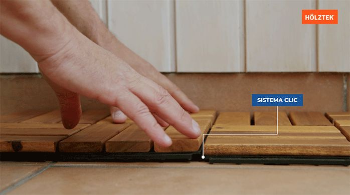 una persona engancha las palmetas de un deck de madera usando el sistema clic.