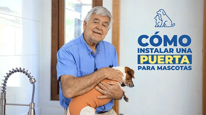 un hombre sosteniendo a un perro, listo para explica cómo instalar una puerta para mascotas.