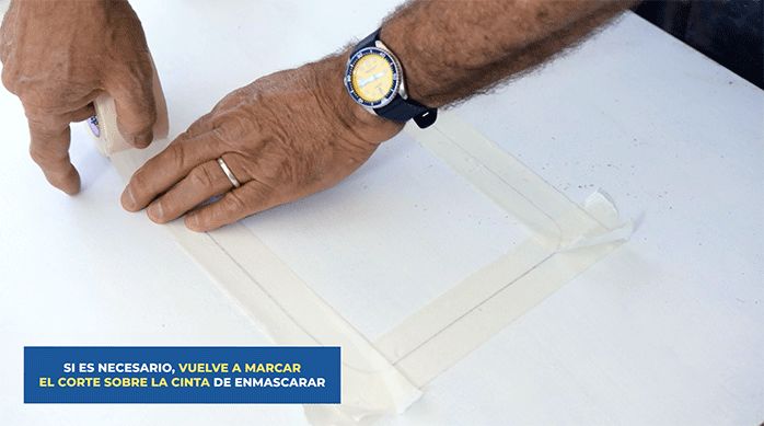 una persona pone cinta para enmascarar sobre el dibujo del contorno de la puerta para mascotas.
