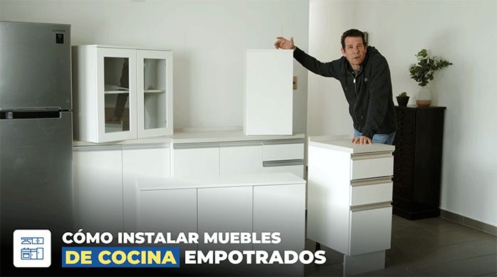 un hombre en una cocina mostrando los muebles modulares flotantes y base que instalará en el muro.