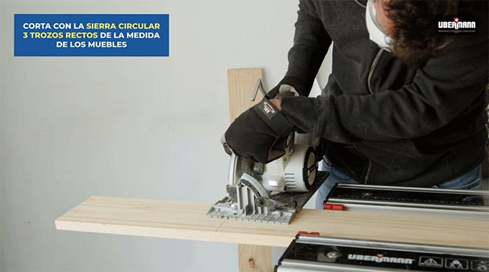 un hombre usa una sierra circular para cortar un listón de madera.