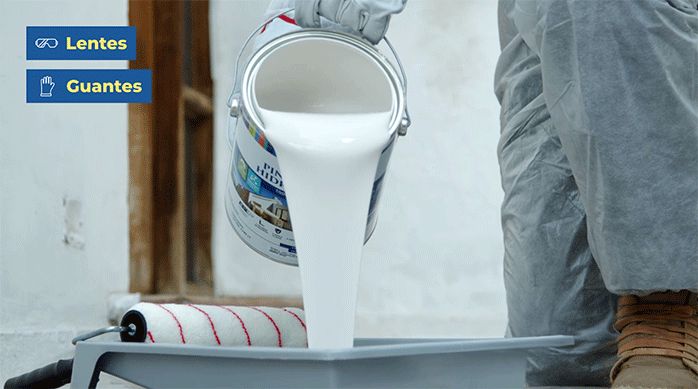 una persona vierte esmalte al agua hidrorrepelente en una bandeja para pintar.