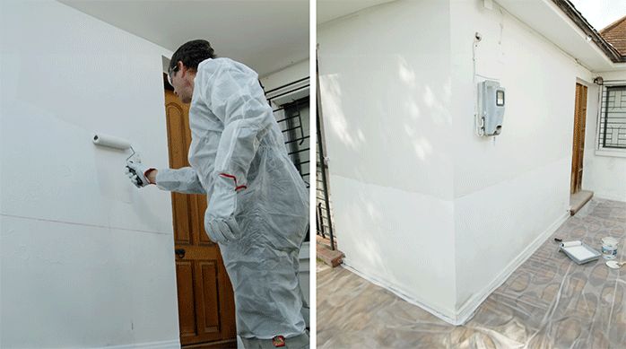 un hombre con overol pinta la fachada de una casa con esmalte al agua hidrorrepelente y un rodillo antigoteo.