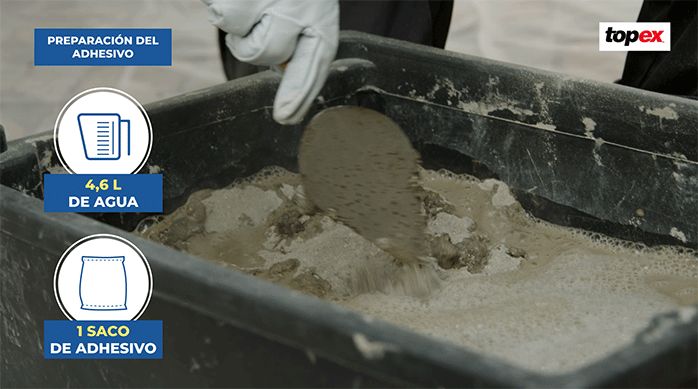 una persona prepara el adhesivo para piedra y porcelanato con agua y una espátula.