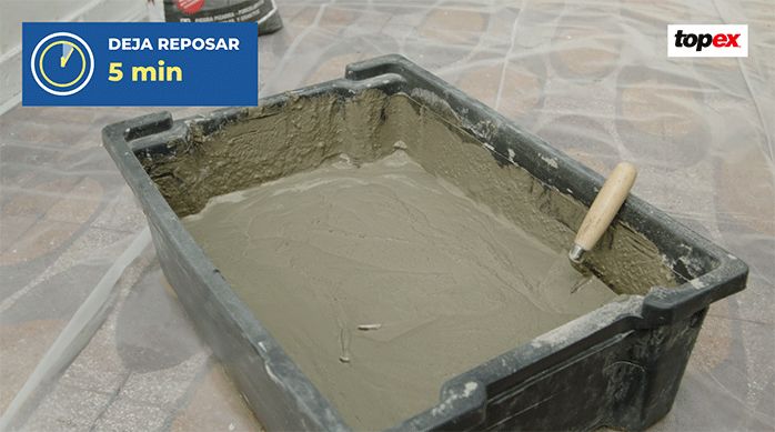 adhesivo para piedra y porcelanato topex recién preparado en una batea.
