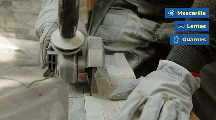 una persona corta una palmeta de piedra natural usando un esmeril angular.