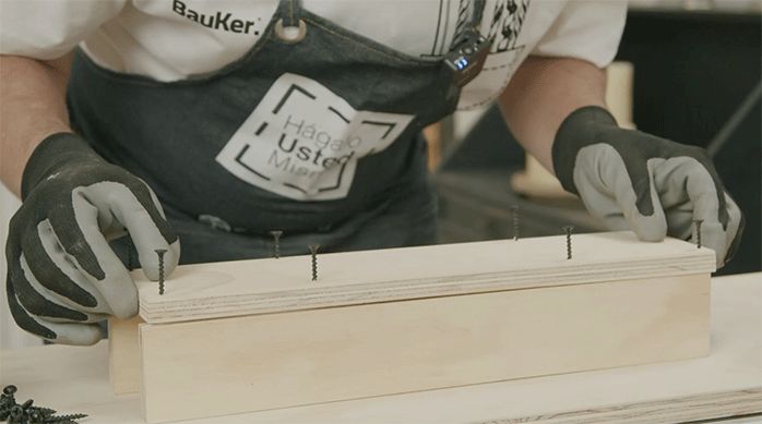 una persona arma una pieza suple de madera usando tornillos.