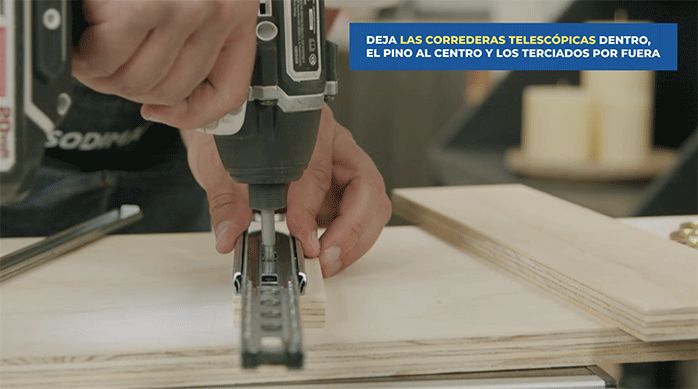 una persona fija una parte del riel telescópico en un trozo de terciado.