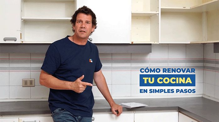 un hombre apoyado en un mesón listo para enseñar cómo renovar tu cocina en simples pasos.