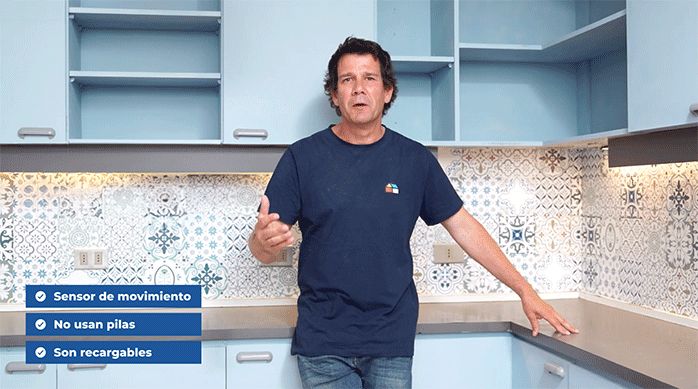 un hombre apoyado en el mesón de una cocina que está siendo renovada con luces ultrafinas led debajo de los muebles, las que además tienen sensor de movimiento, son recargables y no usan pilas.