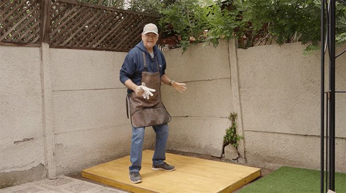 un hombre parado sobre la superficie de madera recién construida para armar la bodega.