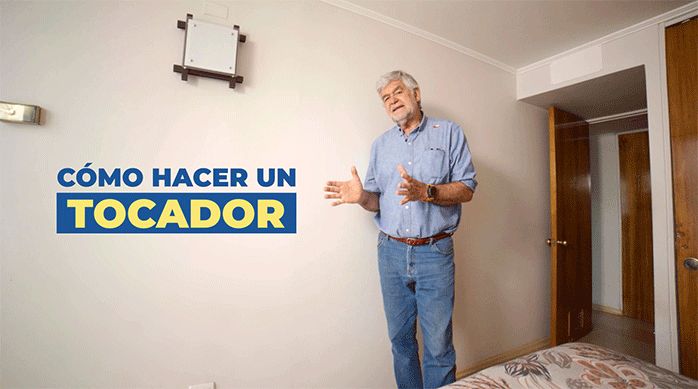 un hombre en una pieza al lado de una pared blanca, listo para enseñar cómo hacer un tocador.