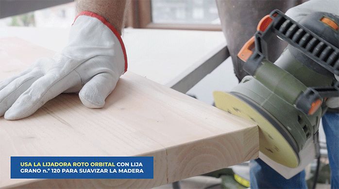una persona usa una lijadora roto orbital con lija n.° 120 para suavizar los bordes de la madera.
