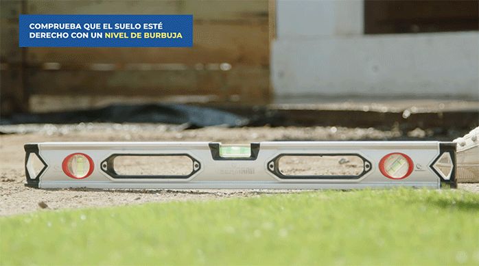 un nivel de burbuja sobre el piso de tierra para verificar que el piso esté nivelado.