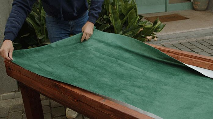 un hombre pone una tela de franela sobre la mesa para juegos.