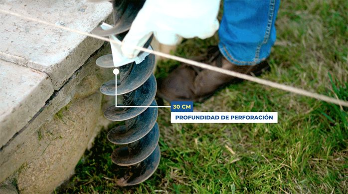 una persona indica el lugar hasta donde va a perforar con el barreno del ahoyador.