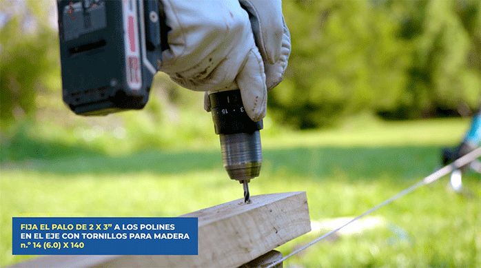 una persona fija el trozo de pino a un polín usando tornillos para madera n.° 14.
