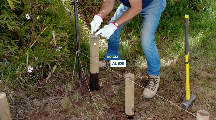 un hombre muestra que instaló el último polín a 50 cm de separación.