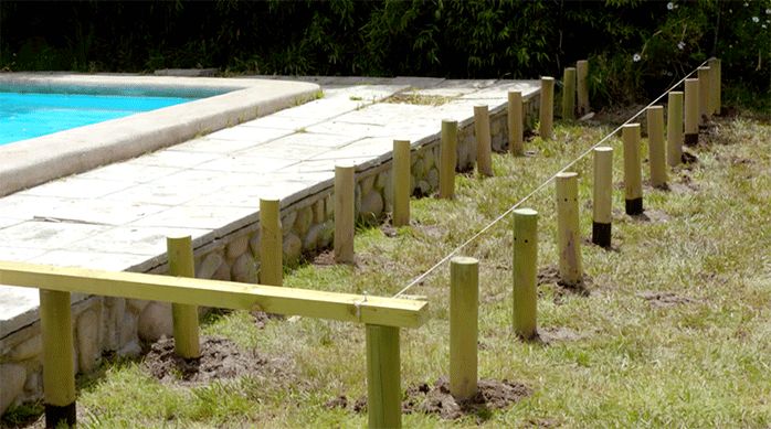 las dos hileras de polines recién enterrados para construir la base del deck de madera para piscina.