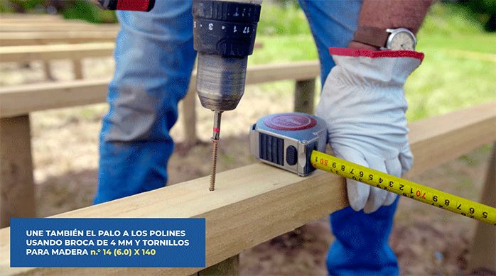 una persona fija un trozo de pino a un polín usando tornillos para madera n.° 14.