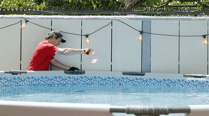 un hombre vierte decantador en una piscina circular.