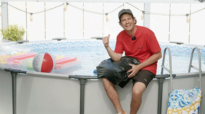 un hombre sentado en el borde de una piscina estructural.