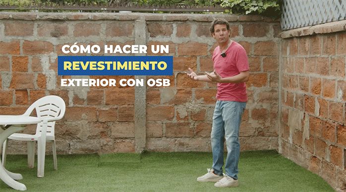 un hombre parado frente a un muro exterior en un patio listo para enseñar cómo revestir un muro exterior con osb.