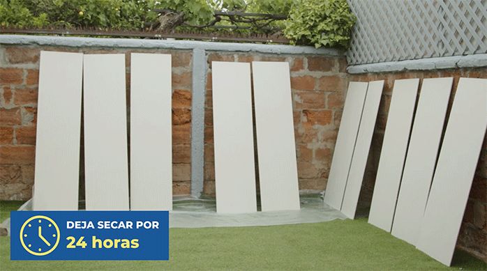 varios tableros de osb apoyados en la pandereta, recién pintados con pintura hidrorrepelente.