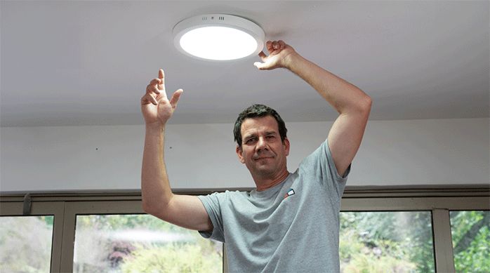 un hombre mostrando cómo quedó el panel led que acaba de instalar.