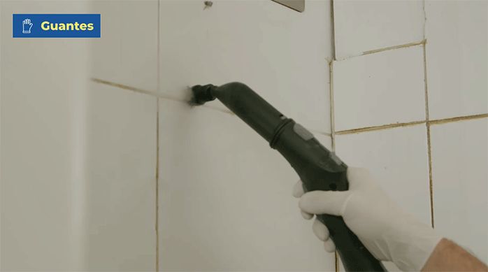 una persona limpia las cerámicas de una cocina usando un limpiador a vapor.
