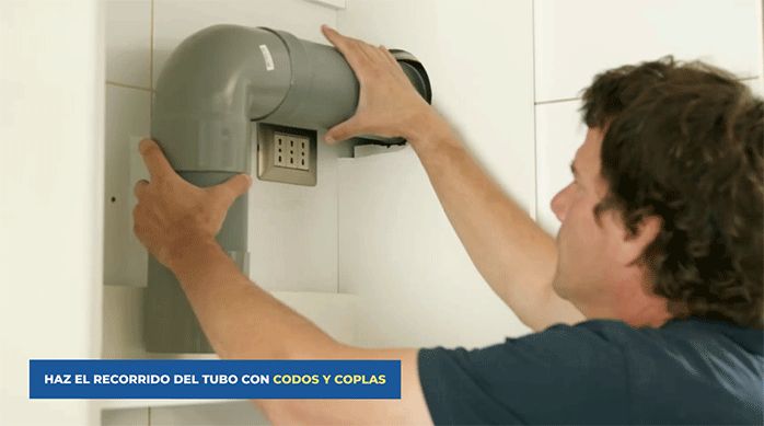 un hombre arma el recorrido del tubo de extracción con codos y coplas de pvc.