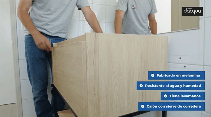 una persona acomoda el mueble vanitorio a la pared del baño.