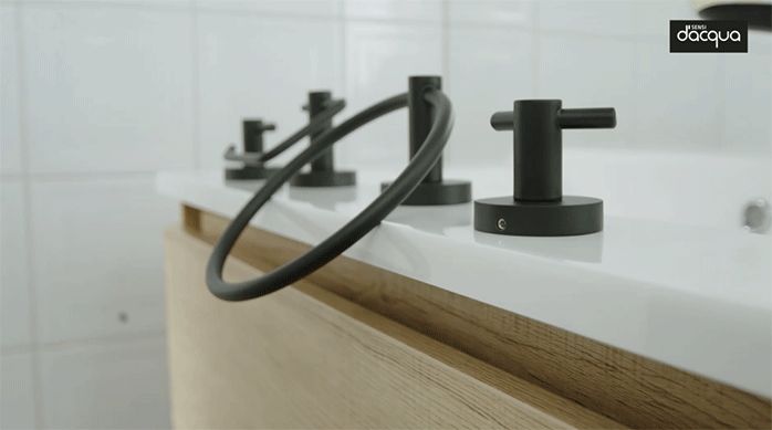 varios accesorios de color negro mate de la marca sensi d'acqua apoyados sobre el lavamanos.