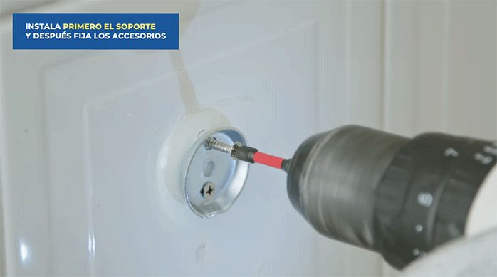 una persona instala el soporte metálico de un accesorio para baño en el muro.