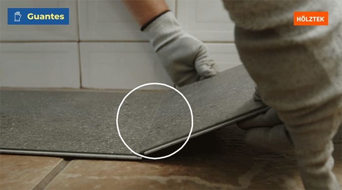 una persona arma el piso vinílico haciendo calzar sus aletas.