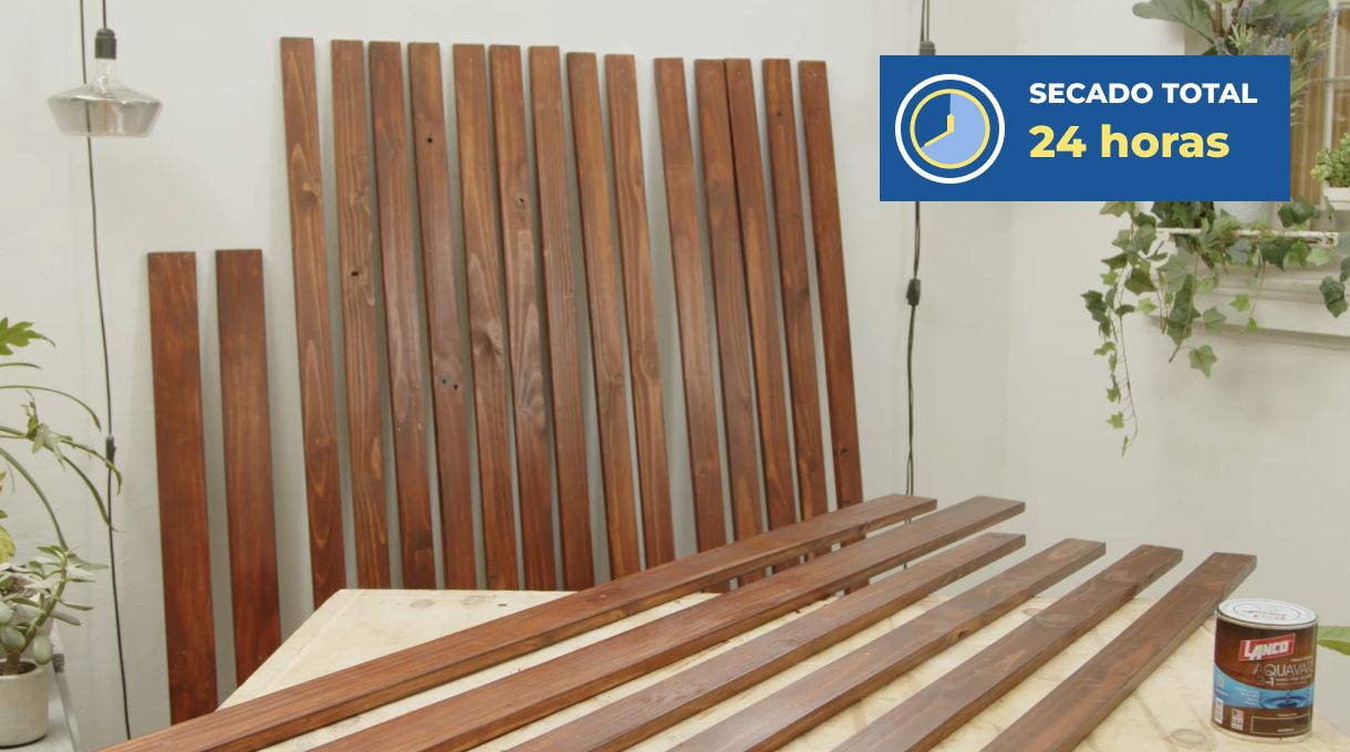 los trozos de pino seco cepillado para hacer el separador de ambientes apoyados en un muro y mesón mientras secan.