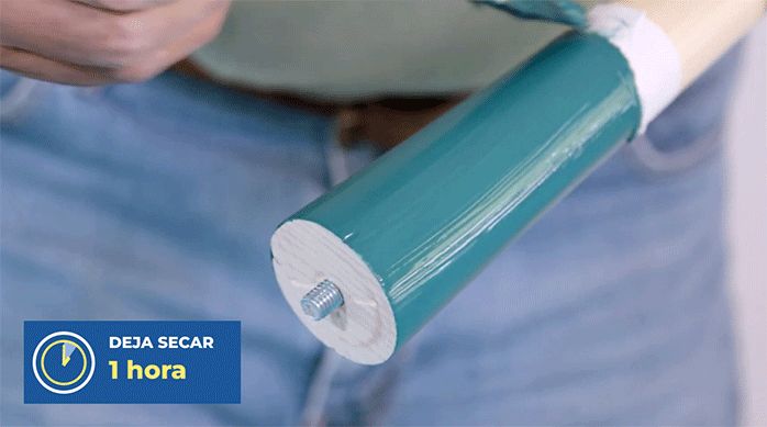 una persona pintando la mitad de una pata de madera.