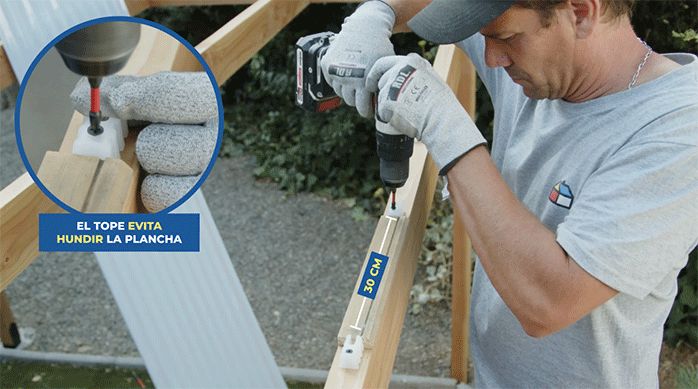 un hombre fija los topes plásticos en el perímetro del cobertizo de madera para instalar el techo de policarbonato.