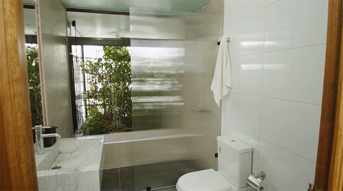 un hermoso baño con una mampara de ducha recién instalada.