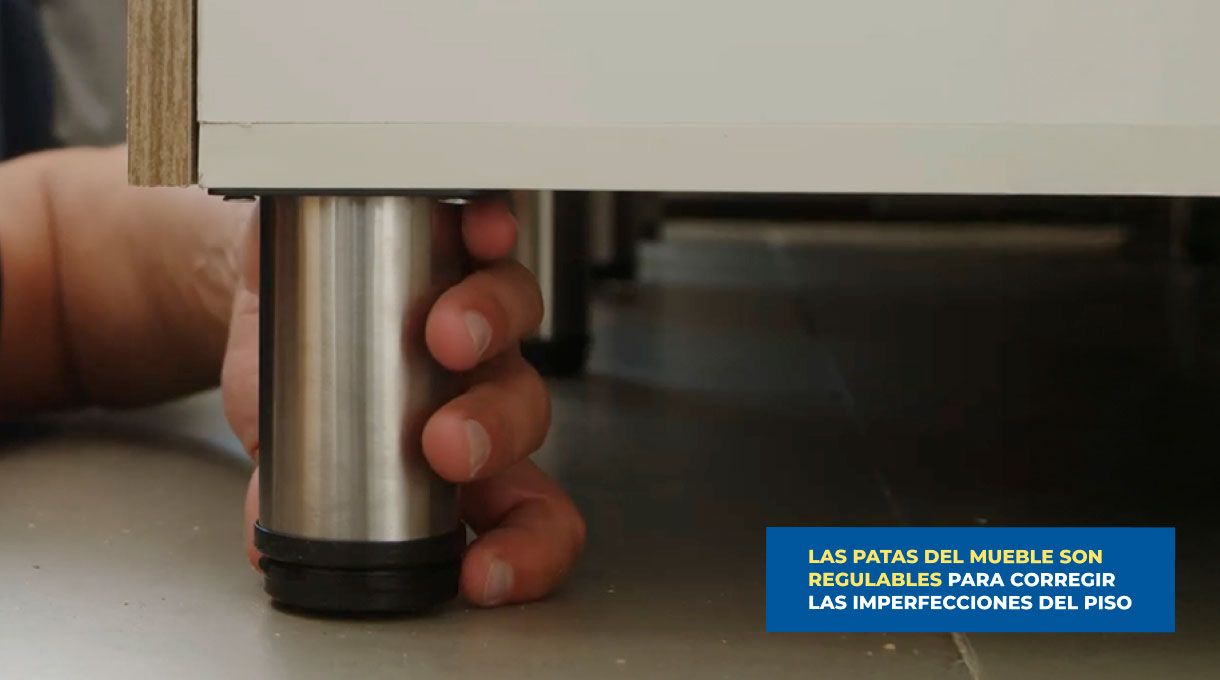 una persona regula las patas del mueble de cocina.