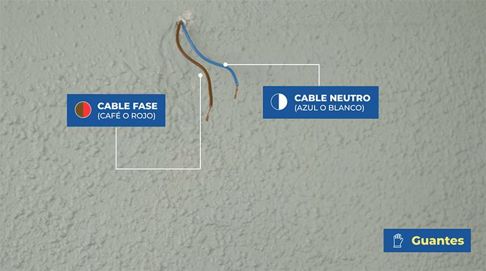 una conexión eléctrica con los cables fase y neutro a la vista, en un muro interior.