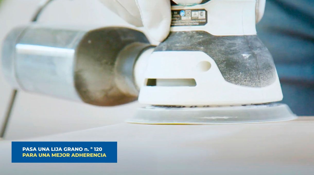 una persona pasa una lijadora roto orbital en los muebles de cocina.