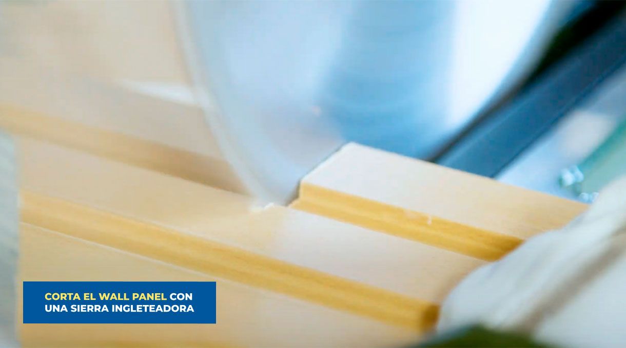 una persona corta un trozo de wall panel con una sierra ingleteadora.