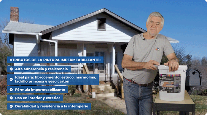 un hombre mayor con polera gris con un tarro de pintura impermeabilizante frente a una casa con revestimiento de siding color blanco.